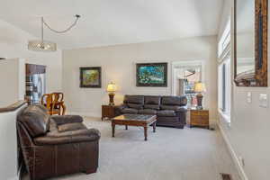 Carpeted living room featuring a towering ceiling