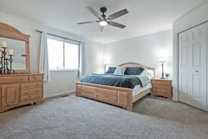 Carpeted bedroom featuring ceiling fan