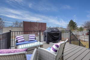 Wooden terrace featuring a grill and outdoor lounge area