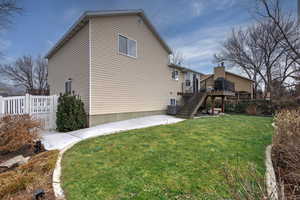 Exterior space with a wooden deck, central AC, and a lawn