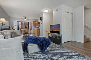 Living room with dark hardwood / wood-style floors and ceiling fan