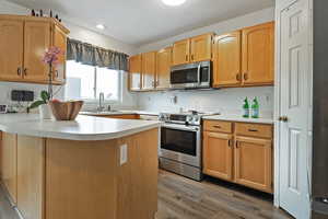 Kitchen featuring hardwood / wood-style flooring, appliances with stainless steel finishes, and sink