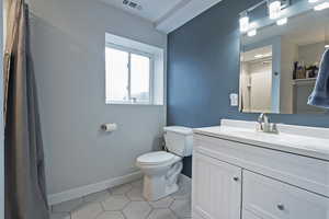 Bathroom featuring tile patterned flooring, vanity, and toilet