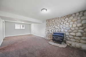 Basement with carpet flooring and a wood stove