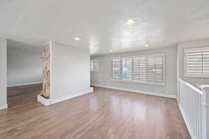 Empty room featuring wood-type flooring and a textured ceiling