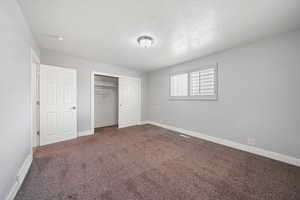 Unfurnished bedroom featuring carpet floors, a closet, and a textured ceiling