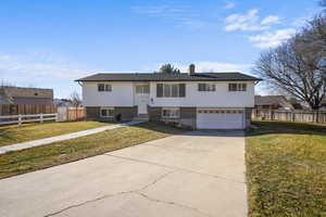 Split foyer home with a garage and a front lawn