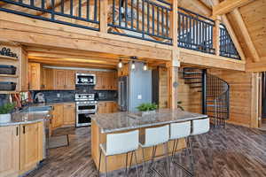 Kitchen featuring appliances with stainless steel finishes, dark hardwood / wood-style floors, light stone counters, wooden ceiling, and beamed ceiling