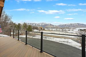 Snow covered deck with a mountain view