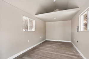 Interior space with hardwood / wood-style flooring and vaulted ceiling