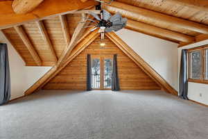 Bonus room featuring carpet, vaulted ceiling with beams, a wealth of natural light, and wooden ceiling