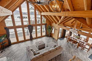 Living room featuring hardwood / wood-style flooring, a mountain view, lofted ceiling with beams, and a notable chandelier