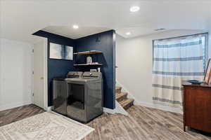 Laundry area with separate washer and dryer and hardwood / wood-style floors