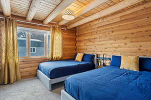 Bedroom featuring beamed ceiling, wood ceiling, and carpet