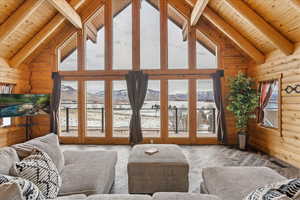 Living room with hardwood / wood-style floors, wood walls, beamed ceiling, a mountain view, and wooden ceiling