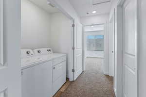 Laundry area with washing machine and dryer and light colored carpet