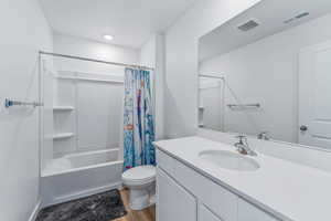 Full bathroom with shower / tub combo, hardwood / wood-style floors, vanity, and toilet