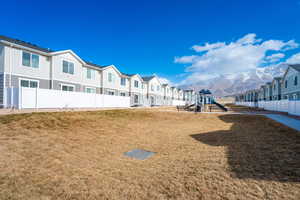 View of community featuring a mountain view, a yard, and a playground