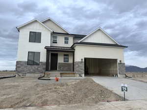 View of front of house with a porch, a garage, and a mountain view