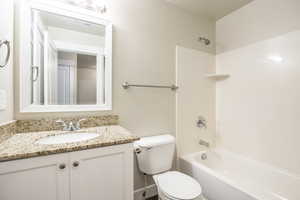 Full bathroom with vanity, shower / washtub combination, and toilet