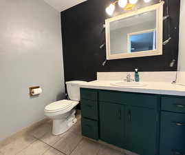 Bathroom featuring vanity, toilet, and tile patterned flooring