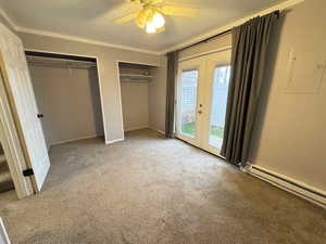 Unfurnished bedroom with access to exterior, carpet floors, ornamental molding, french doors, and multiple closets