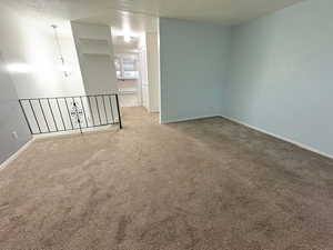 Empty room featuring carpet floors and a textured ceiling