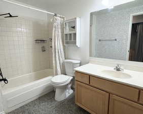 Full bathroom with shower / tub combo with curtain, vanity, tile patterned flooring, and toilet