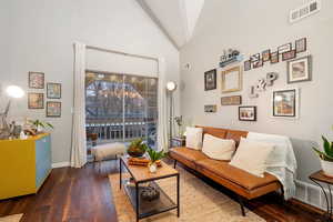 Living area featuring dark wood-type flooring and high vaulted ceiling