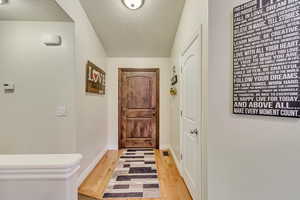 Doorway with hardwood / wood-style floors and a textured ceiling