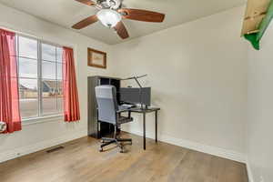 Office space with ceiling fan and light wood-type flooring