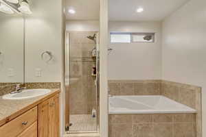 Bathroom featuring vanity and plus walk in shower