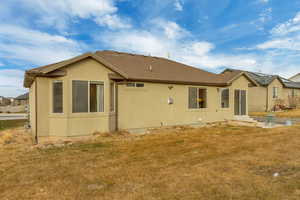 Rear view of house featuring a lawn