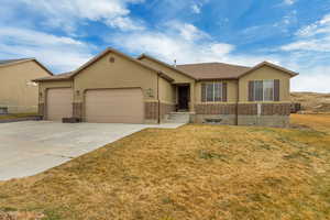 Single story home with a garage and a front lawn