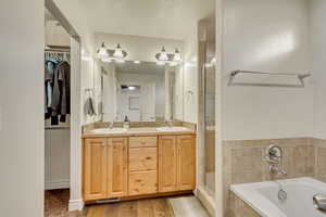 Bathroom with wood-type flooring, plus walk in shower, and vanity