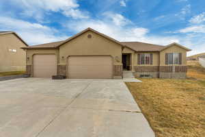 Single story home with a garage and a front yard