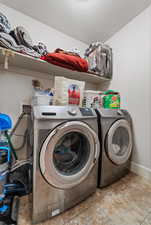 Laundry room with light tile patterned flooring, separate washer and dryer, and a textured ceiling