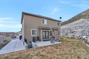 Rear view of property with a yard, a patio area, and french doors