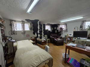 Bedroom with hardwood / wood-style flooring and a textured ceiling