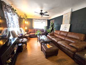 Living room with ceiling fan and light hardwood / wood-style floors