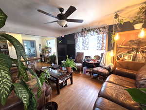 Living room with light hardwood / wood-style flooring and ceiling fan