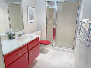 Hall full Bathroom with vanity, tile flooring, toilet, and walk in shower