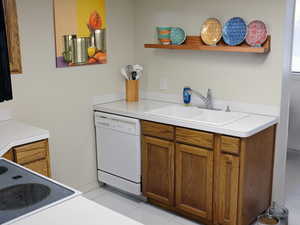 Kitchen featuring sink, white appliances, and light tile