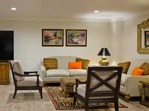 Living room with crown molding and light hardwood / wood-style flooring