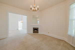 Formal living room featuring light colored carpet and a chandelier