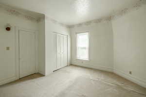 Master Bedroom with light colored carpet,  and a closet