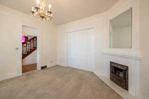 Formal living room with carpet flooring and an inviting chandelier