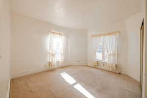 Bedroom featuring light colored carpet and a healthy amount of sunlight