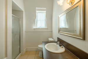 Upstairs Bathroom with an enclosed shower, sink, tile patterned floors, and toilet