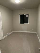 Spare room with a textured ceiling and carpet